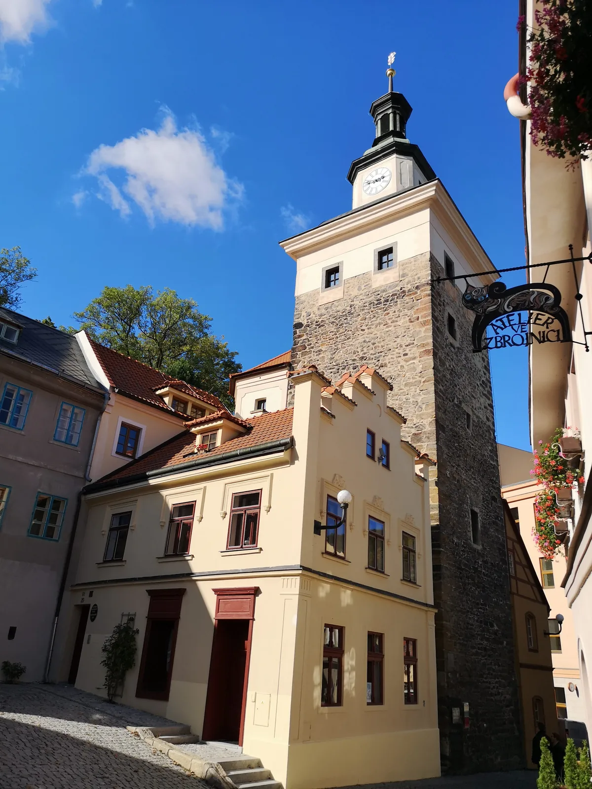 Steinerner Turm mit Uhr in einer Gasse der Altstadt von Loket