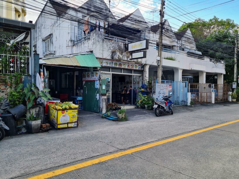 Straße in Phuket mit einem Wirrwarr an Kabeln, kleinen Restaurants und Läden