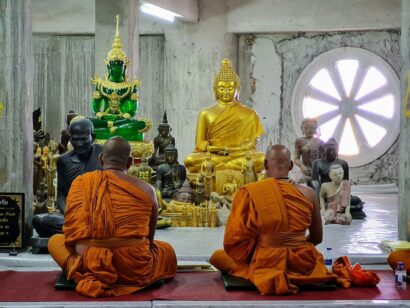 Phuket, Thailand - Tempel mit Mönchen in orangefarbenen Gewändern beim Gebet