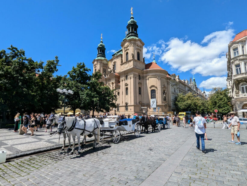 Prag, St. Nikolaus in der Altstadt mit Kutsche im Vordergrund